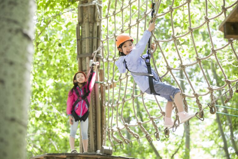 Little girls playing in tree top adventure park