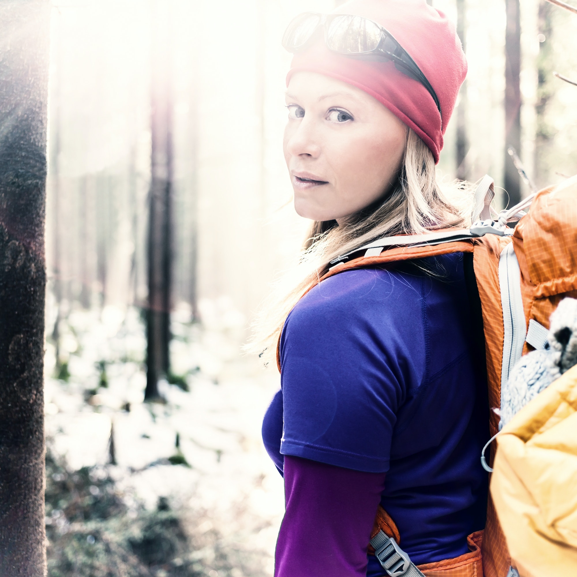 Woman hiking camping in vintage winter forest sunlight